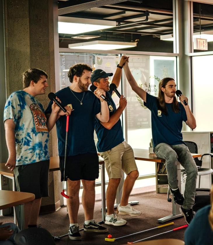 four students singing karaoke